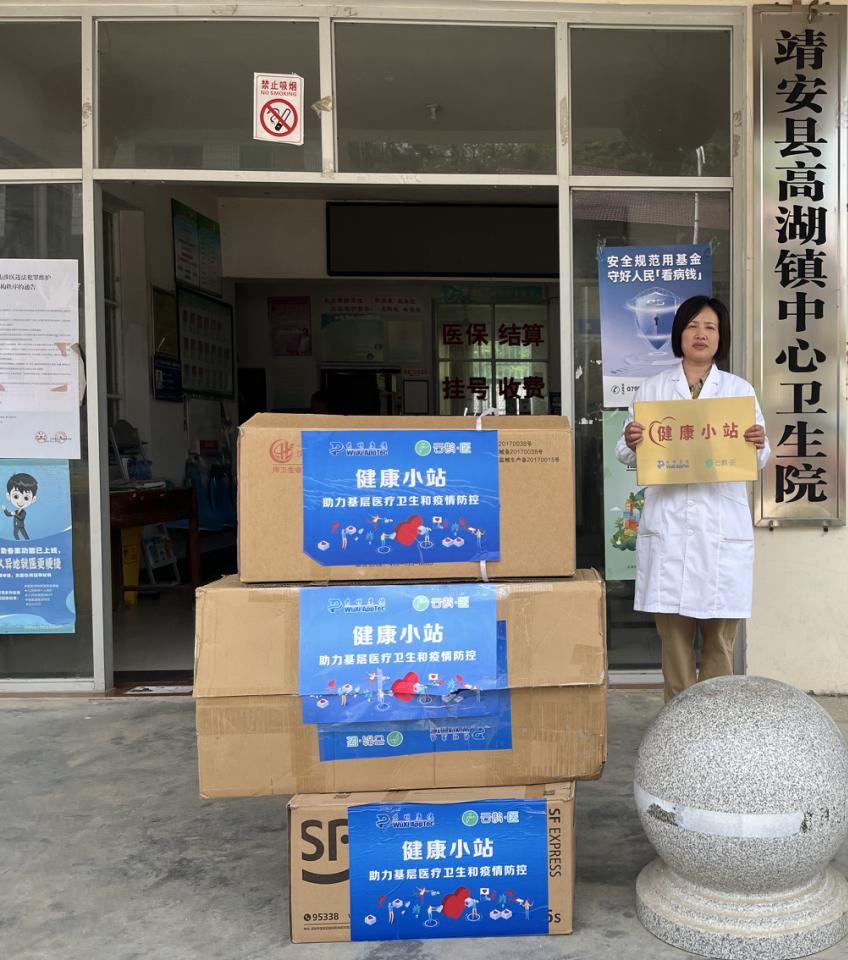 A physician stands with newly delivered health-station supply boxes at a township health centre in Jiangxi