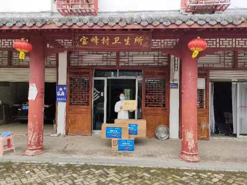 A village clinic housed in a traditional building receives health-station supplies